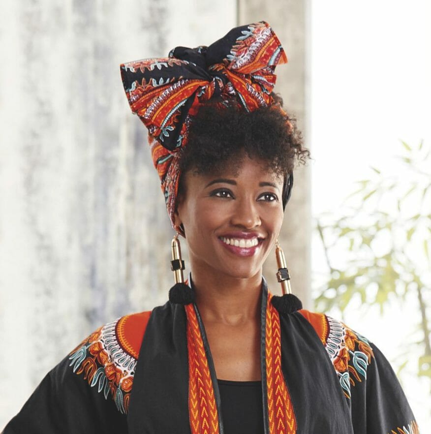 Black woman wearing black, red, orange, white print headwrap