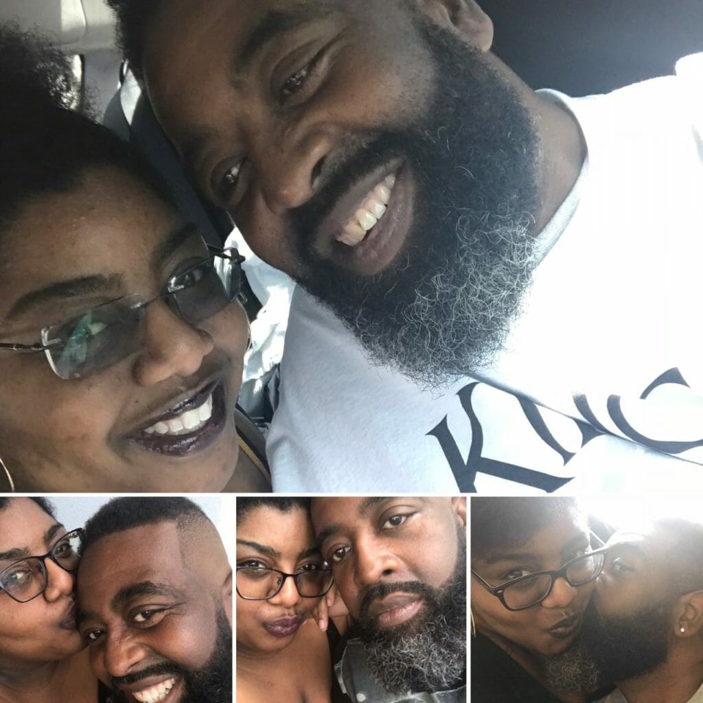 A smiling African-American couple, heads together, and giving each other kisses.