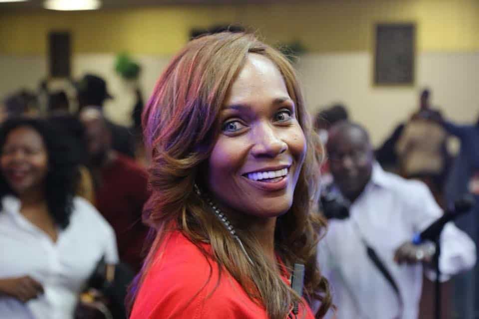 Ashro Woman of the Week, Dr. Angela, a smiling African-American woman with light brown hair, wearing a red suit.