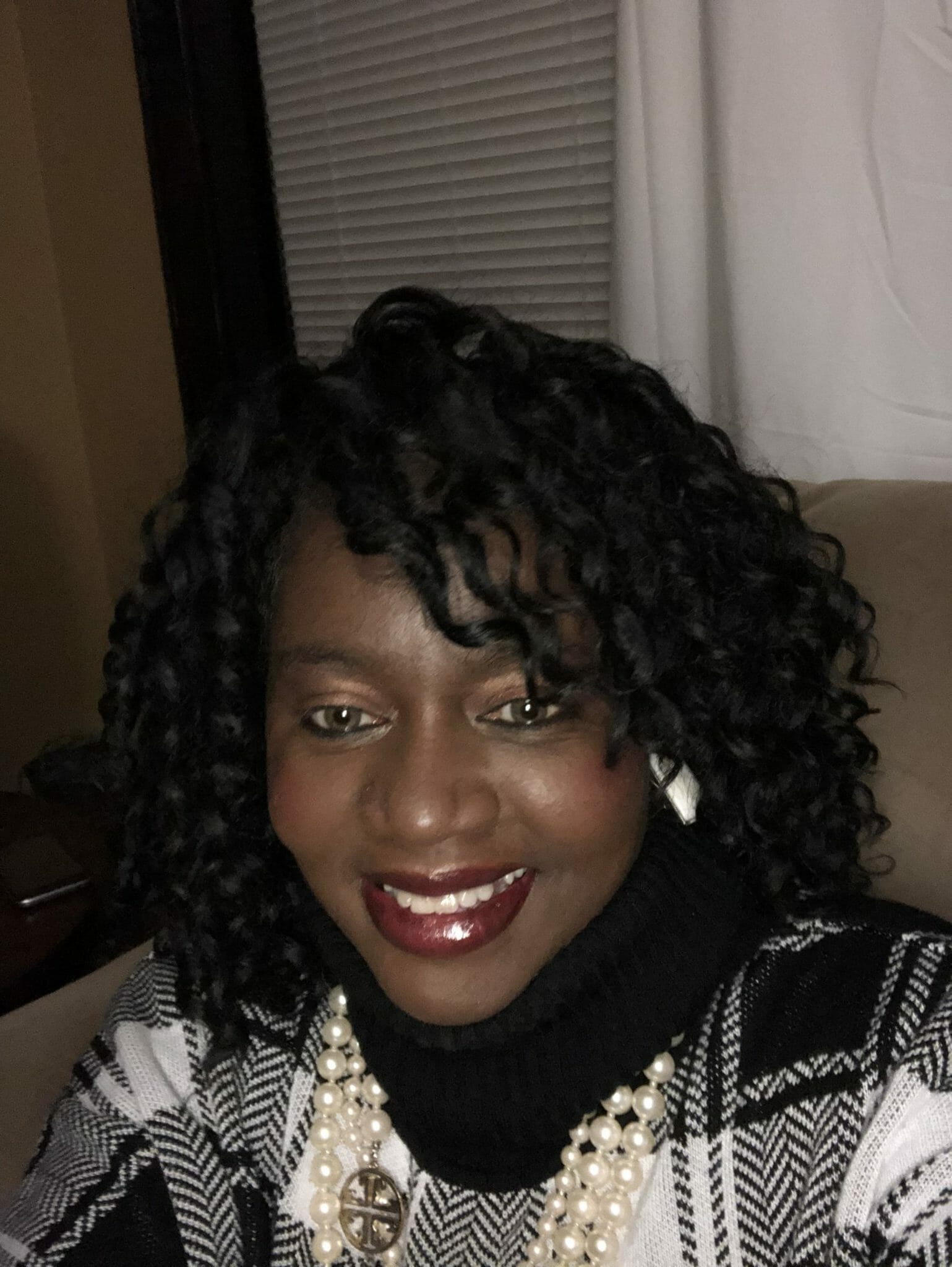 Ashro Woman of the Week, Seletha, a smiling black woman with curly hair and bangs, wearing white earrings.