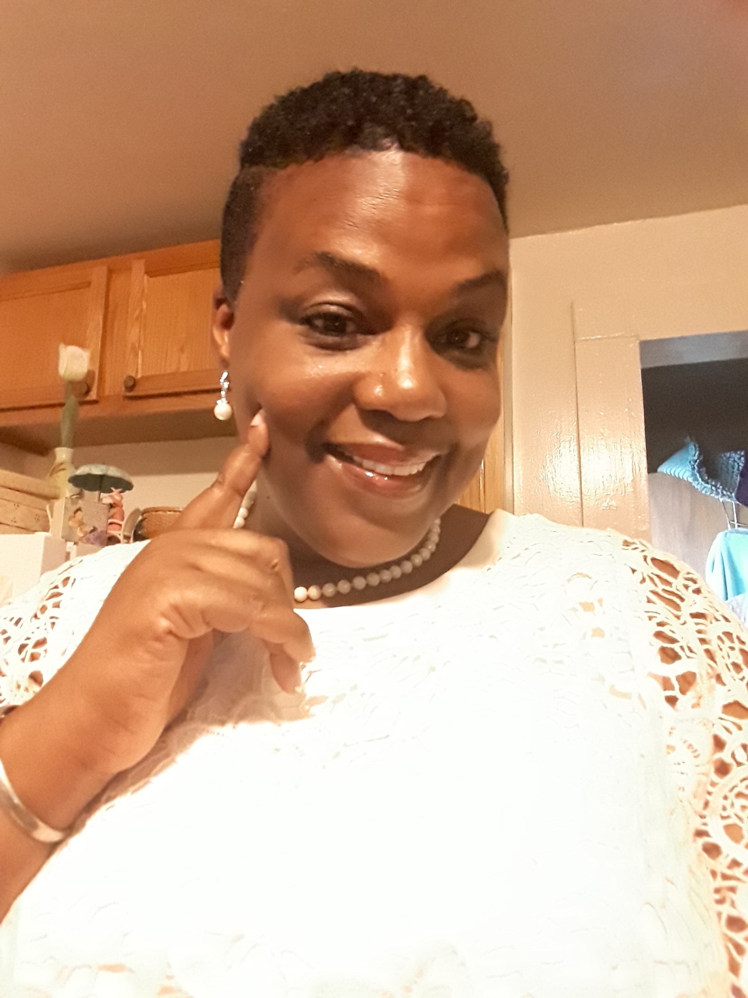 Ashro Woman of the Week MICHELLE, a smiling African-American woman with short hair, wearing a white dress.