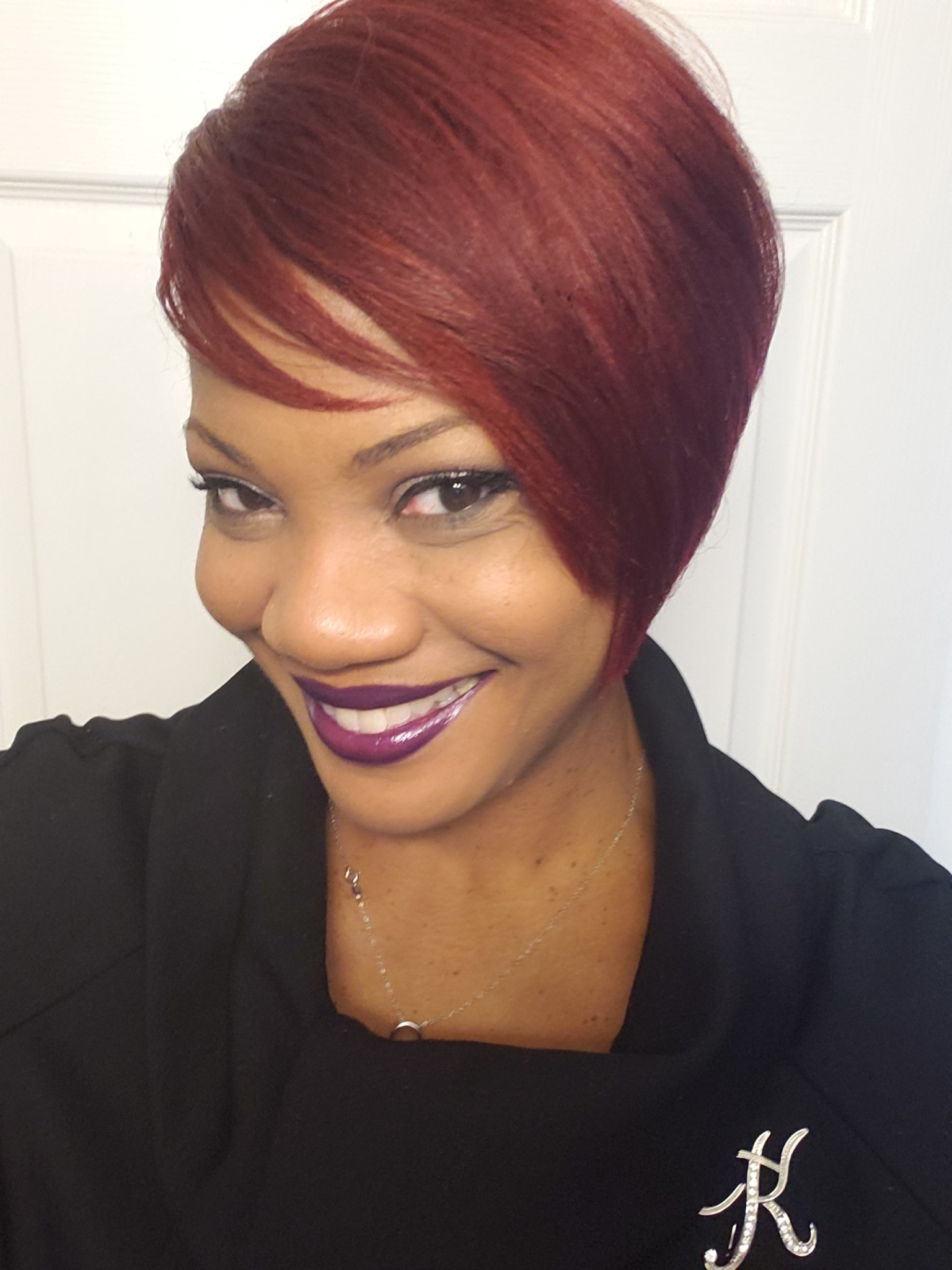 Ashro Woman of the Week Karen a smiling African-American woman wearing a black jacket and has red hair.