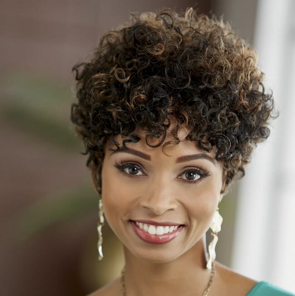 Black woman wearing a short curly wig and a teal top