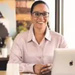 Suzanne, Ashro Merchandise Director at desk with laptop and coffee