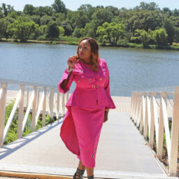 Vertical Image of Woman posing at a water front in a two piece pink suit set