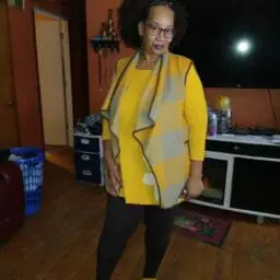 Ashro customer posing wearing yellow shirt and blazer