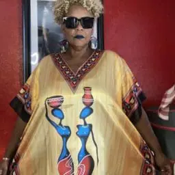 Image of a woman wearing a caftan with African imagery.