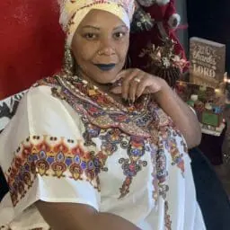Image of Woman wearing multicolor caftan with matching head wrap.