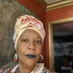 Image of Woman wearing multicolor caftan with matching head wrap.