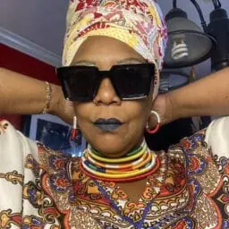 Image of Woman wearing multicolor caftan with matching head wrap.