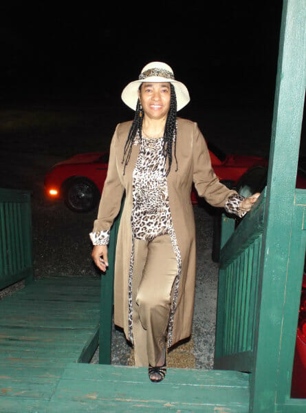 woman standing on porch steps in khaki outfit