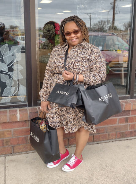 woman holding shopping backs in front of a store