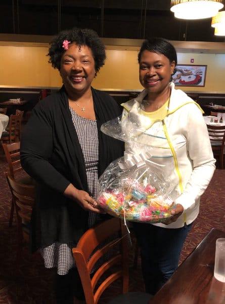 two women holding a gift basket