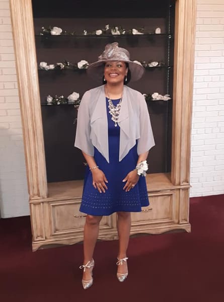 woman in white and blue outfit with a hat