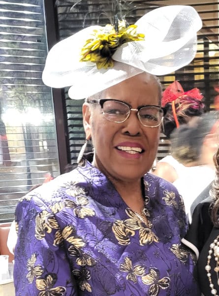 woman in a hat and purple floral dress