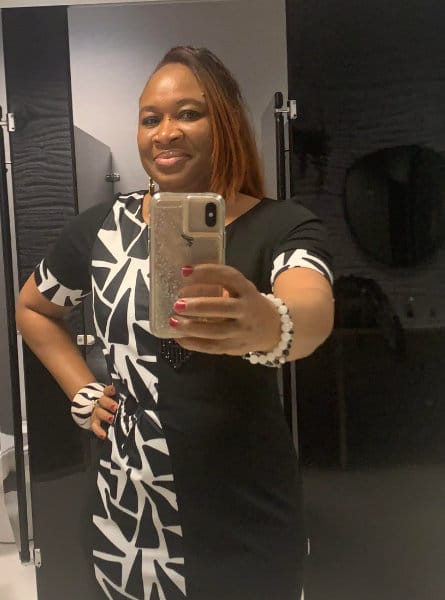 woman in a black and white dress taking a selfie