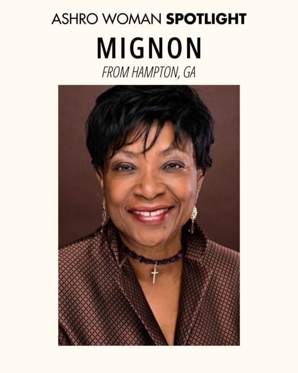 Social post. A smiling woman with short black hair wears a patterned brown jacket, gold earrings, and a purple beaded necklace with a cross pendant. She is posed against a plain brown studio background.