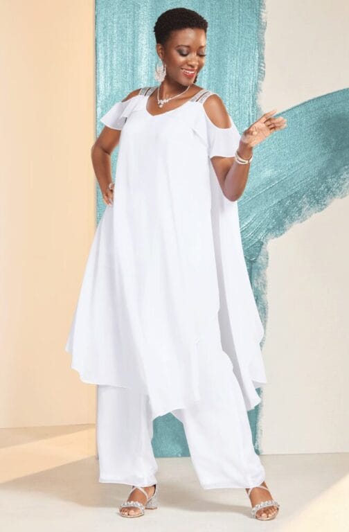 black model in white flowy outfit with cold shoulder detail