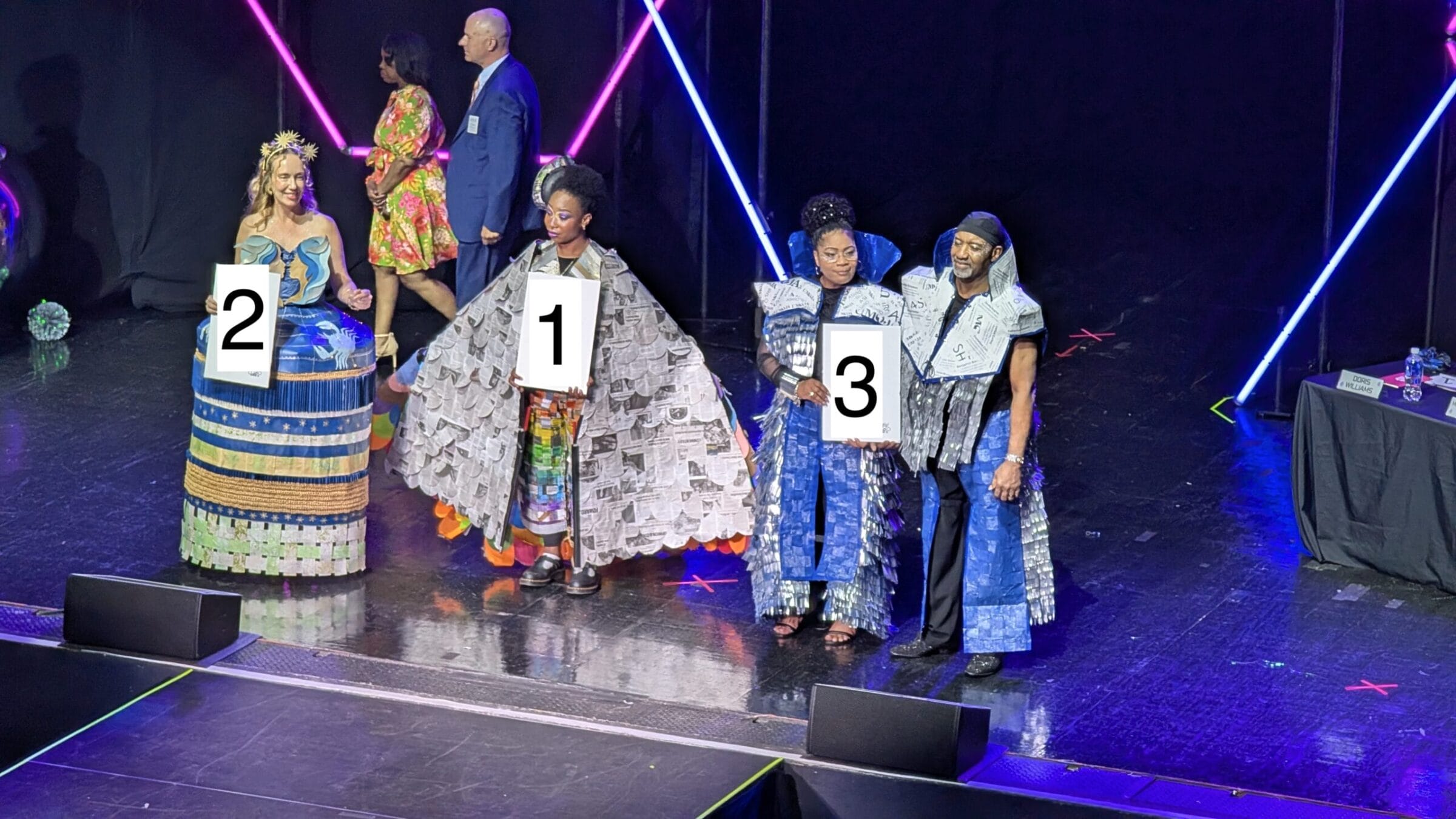 Image is of top three candidates winning showcasing their designs.