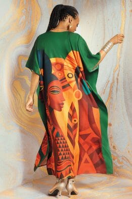 Woman in green kaftan with bold African art print of a face and geometric patterns.