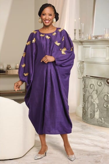 Woman in a purple butterfly-embellished dress and sparkly heels.