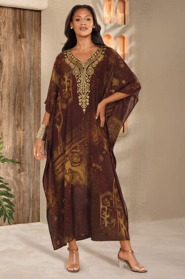 Woman in brown kaftan with gold embroidery and abstract print.
