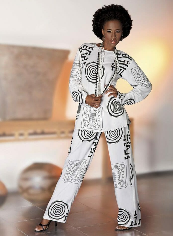 Black woman wearing white pantsuit with Afrocentric black print