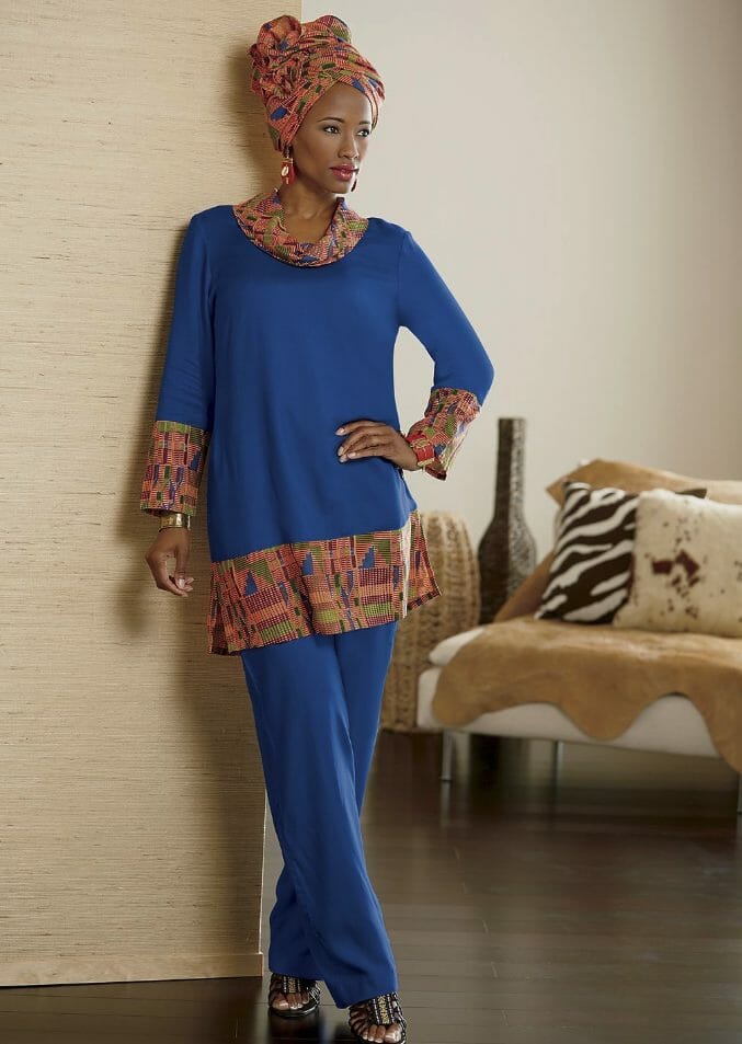 Black woman in blue pantsuit with Kente cloth pattern