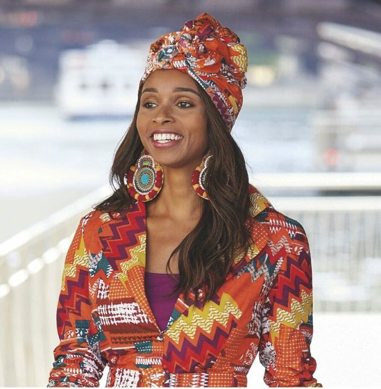 Black woman wearing multicolor, multipring headwrap with matching jacket