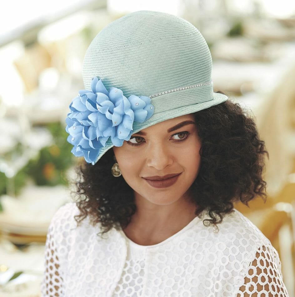 Black woman wearing ice blue rounded top hat with faceted beads and petals