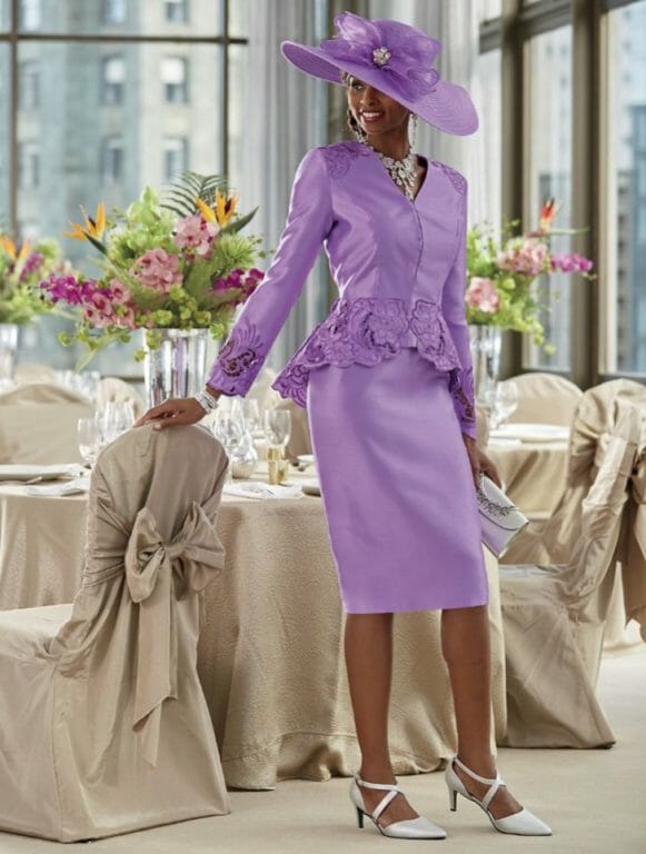 African-American woman in lavendar skirt suit with applique trim and big matching hat