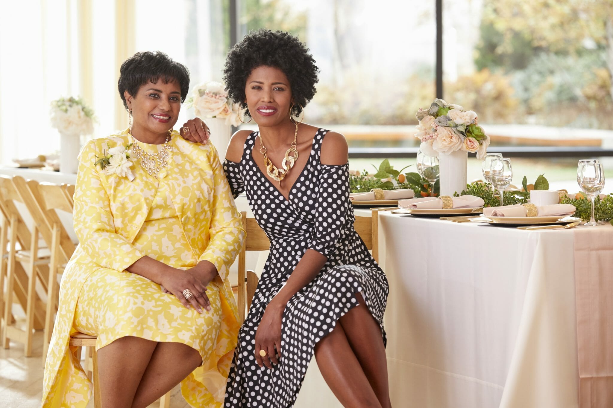 African-American mother and daughter smiling sitting at table