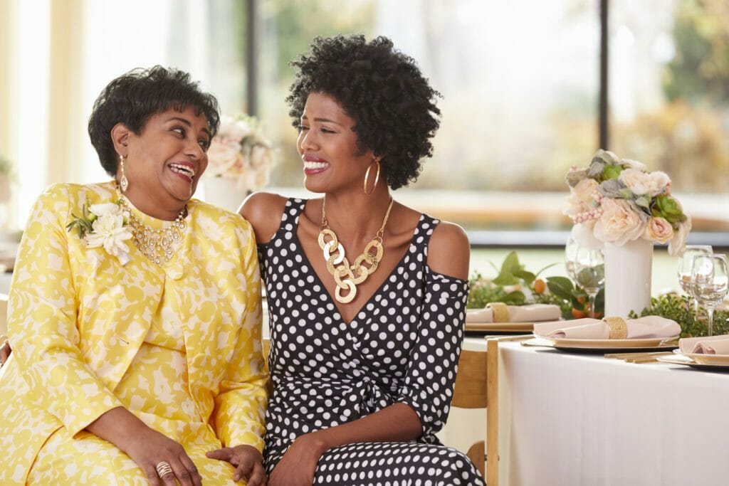 African-American mother and daughter looking at each other and laughing