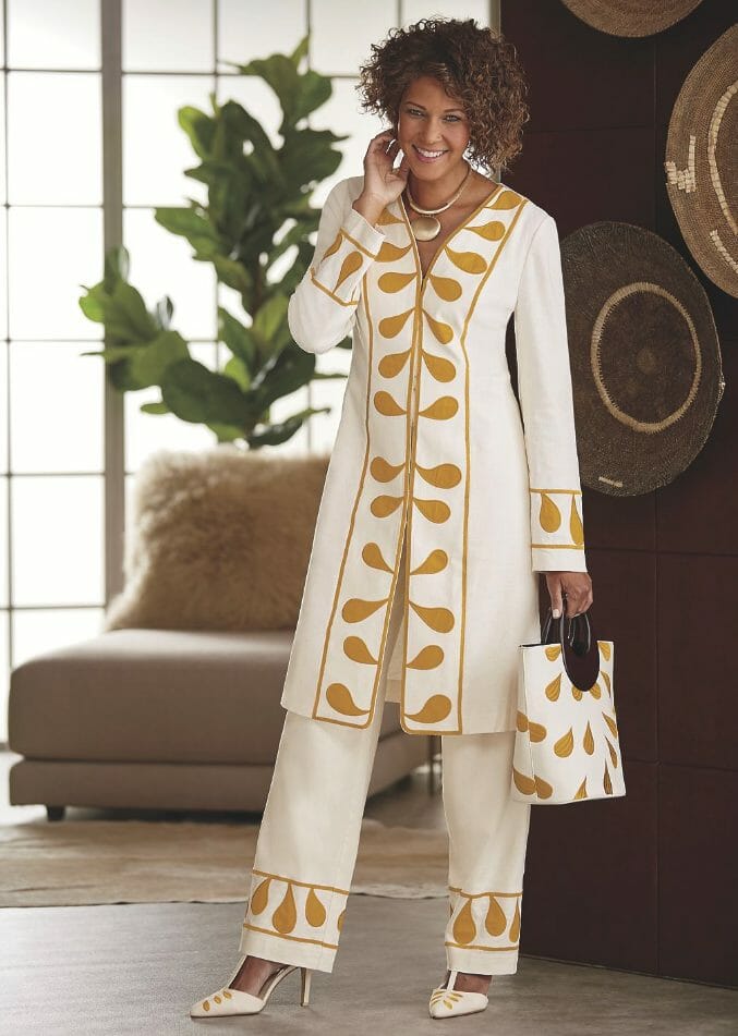African-American woman in ivory and gold pantsuit with matching bag