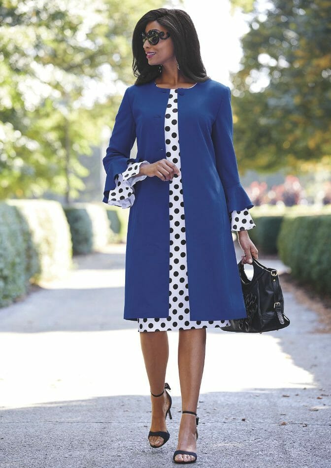 Black woman in with and blue polka dot dress with blue jacket