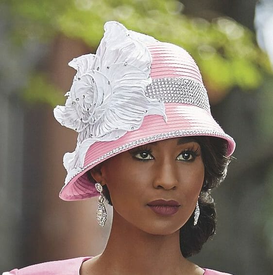 Black woman wearing fancy pink hat with diamonds and white flower