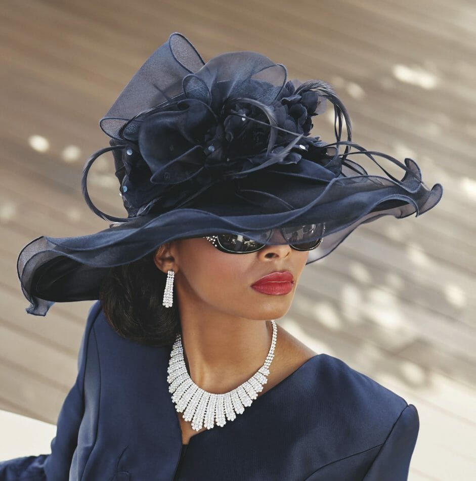 black woman wearing big black hat with mesh flower overlay