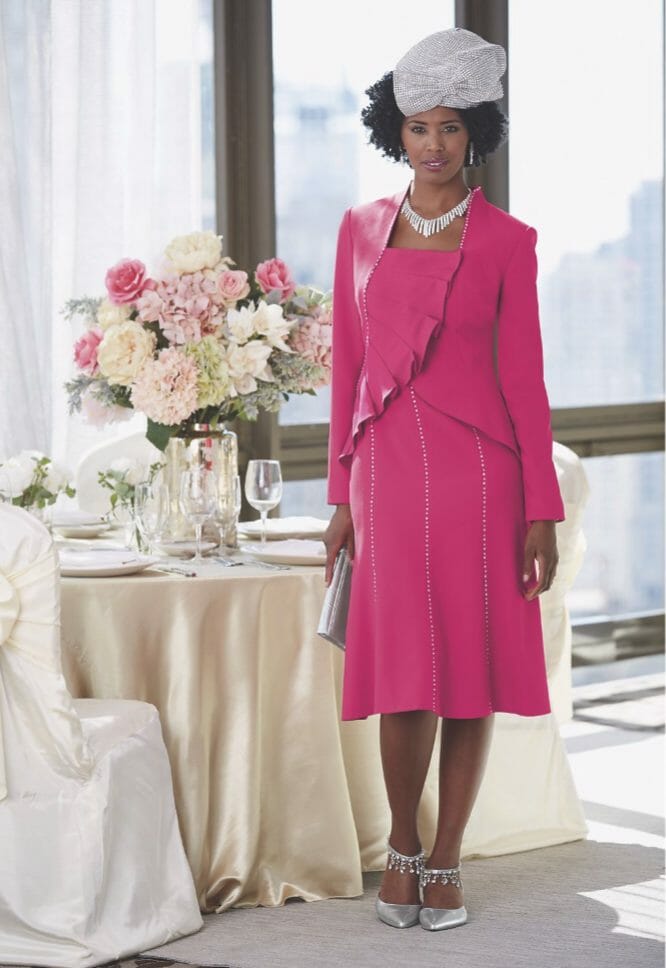 African-American woman wearing bright pink jacket dress with silver bling hat