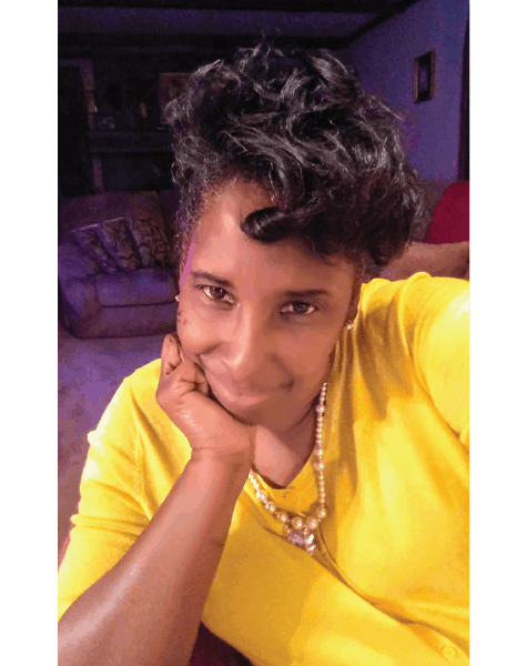 Ashro lookbook customer Crystal, a smiling black woman with short hair and bangs, wearing a bright yellow top.
