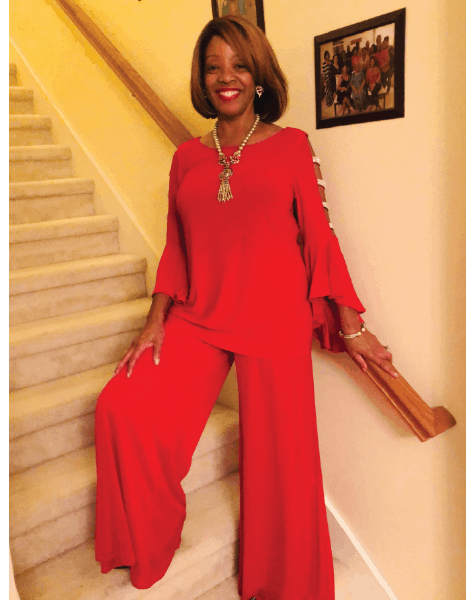 Ashro lookbook customer Cynthia, a smiling black woman with smooth, light brown hair, wearing a flowing red pantsuit.