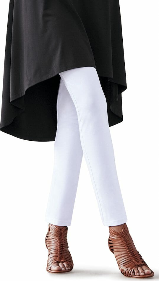 The bottom half of a woman wearing a slim white pant.