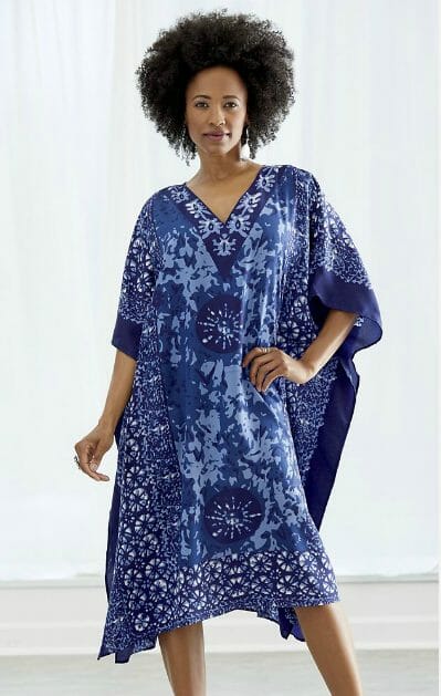 An African-American woman in a blue and navy print short caftan.