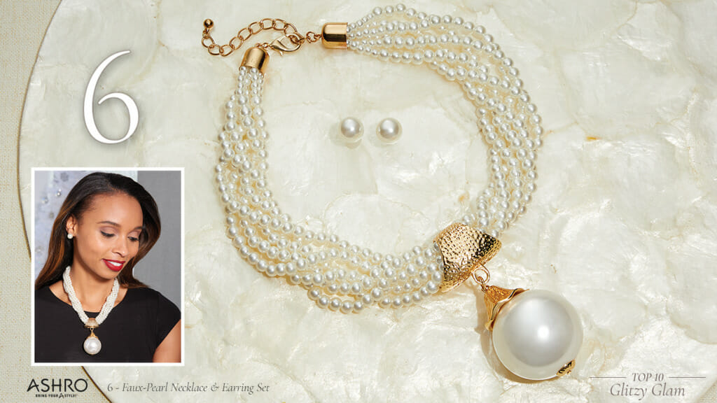 A black woman wearing a faux-pearl multi-strand necklace with a big faux pearl pendant and faux pearl stud earrings.