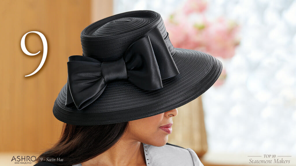 An African-American woman wearing a wide brimmed black hat with a big black bow on the side.