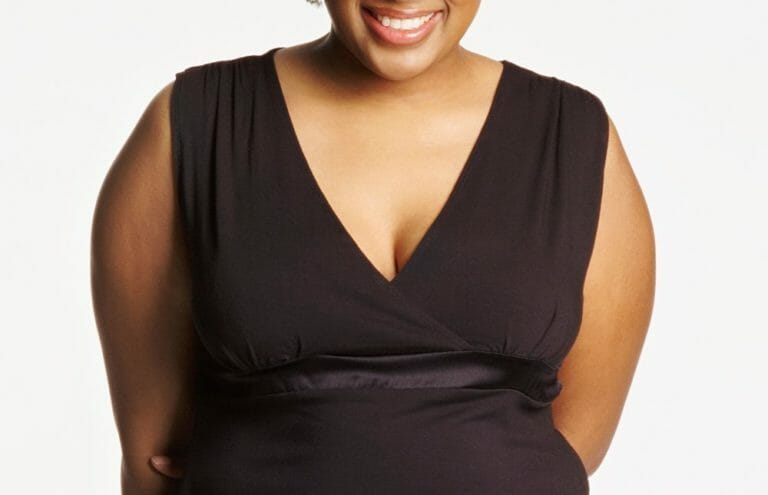 A black woman wearing a black V-neck sleeveless top.