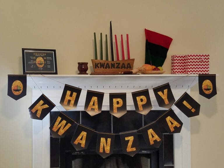 Happy Kwanzaa! banner on a fireplace with Kwanzaa candles on the mantle.