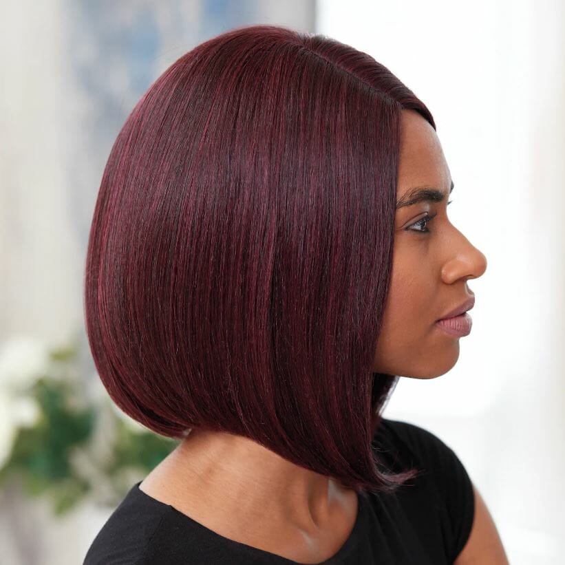 Side view of an African-American woman wearing a sleek, burgundy Vivica Fox wig angled longer to the front.