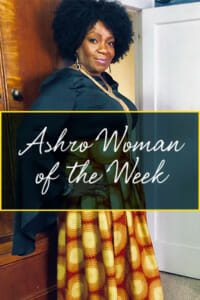 Ashro Woman of the Week, Beverly, a black woman with curly hair, in a black top and long gold and orange skirt.