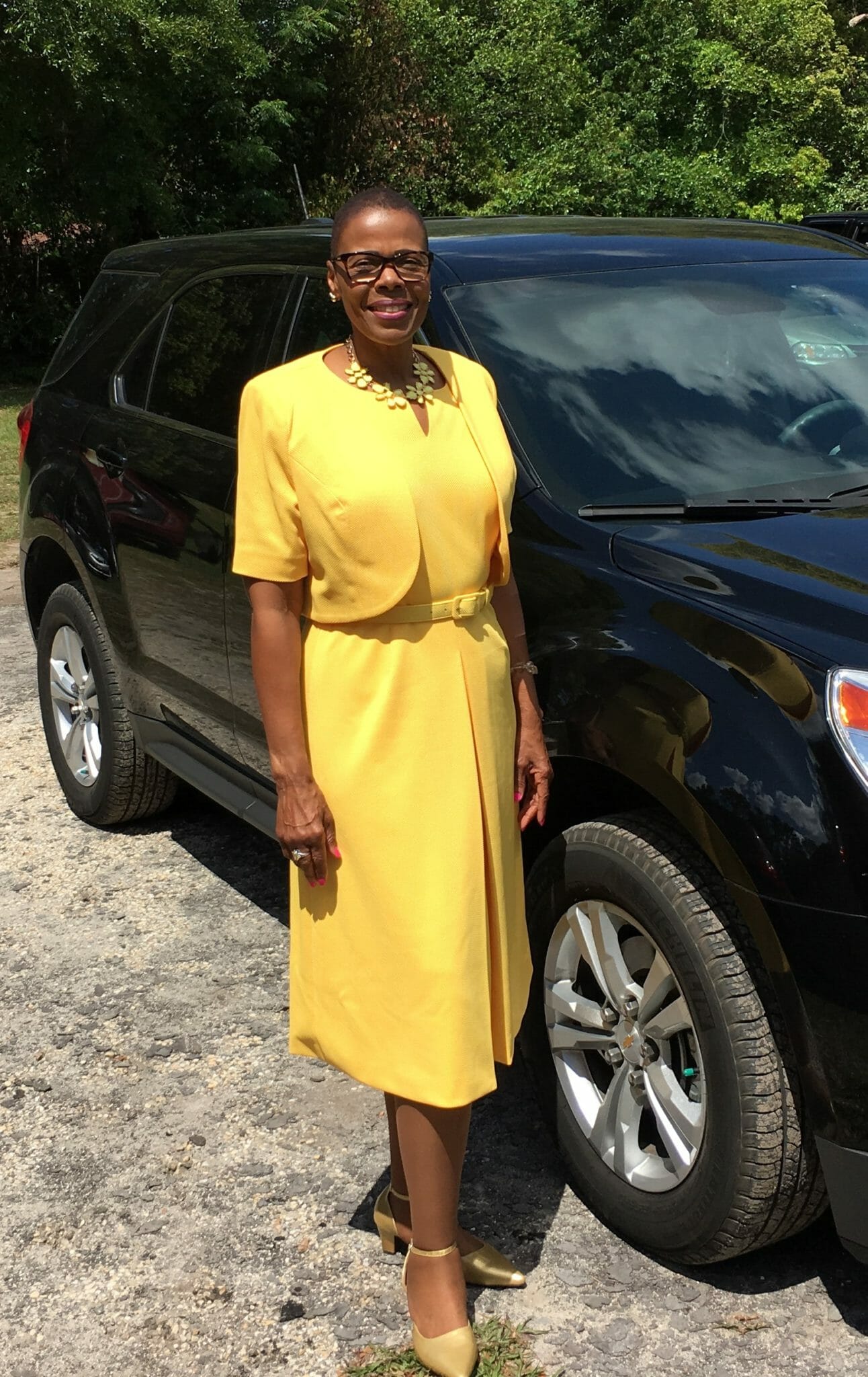 Ashro Woman of the Week, Carolyn, an African-American woman with short hair, wearing a yellow jacket dress.