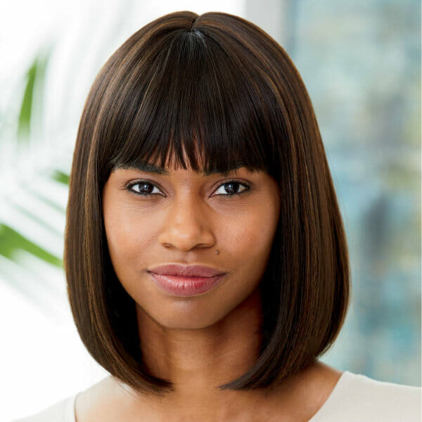 An African-American woman wearing a short, off-black straight Vivica Fox wig with bangs and white top.